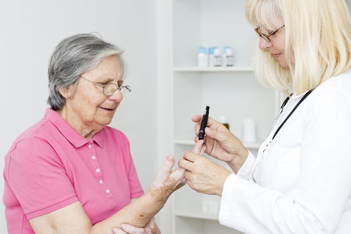 Doctor testing glucose on a patient's finger