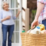 Neighbour bringing food to an elderly lady