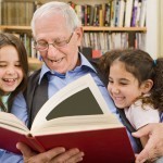 Older man reading to two young girls
