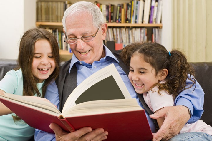 Older man reading to two young girls