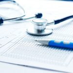 a stethoscope and a pen and medical charts