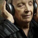 Senior woman listening to music on headphones with her eyes closed