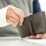 man with broken arm opening his wallet