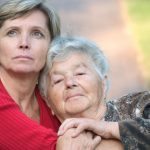 Adult daughter hugging senior mom