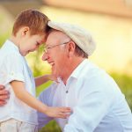 portrait of happy grandfather and grandson bow their heads