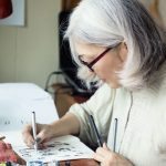 Asian senior woman artist sketching