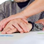 a pair of young hands touching wrinkly hands