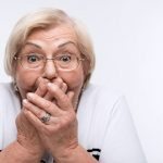 Elderly woman closes her mouth, ears and eyes with hands