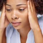 african american woman with headache, looking sad