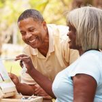 Senior Couple Sitting At Outdoor Table Painting Landscape