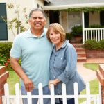 Senior Hispanic couple outside home