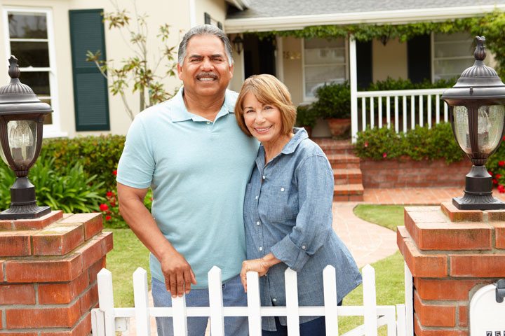 Senior Hispanic couple outside home