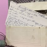 vintage tin recipe box with a handwritten recipe for candy showing in the front.