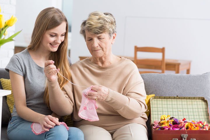 grandma teaching younger woman how to knit