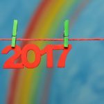 Red 2017 New Year’s Eve numbers with a colorful rainbow and blue sky background sky to illustrate the concept of new beginnings and resolutions.