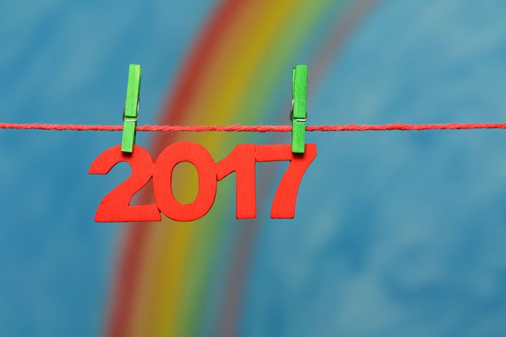 Red 2017 New Year’s Eve numbers with a colorful rainbow and blue sky background sky to illustrate the concept of new beginnings and resolutions.