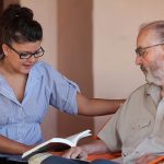 companion or granchild reading to senior or grandfather
