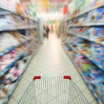 Shopping cart in a grocery food aisle from perspective of shopper .