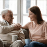 Father and Daughter enjoying a cup of coffee while sitting on the couch together.