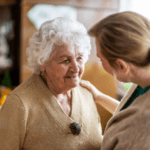 Caregiver offering support to an older female dementia patient